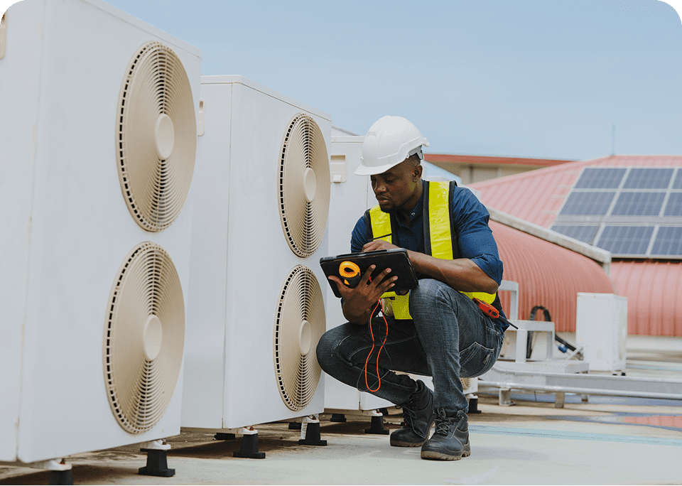 Technician inspecting rooftop air conditioning units.