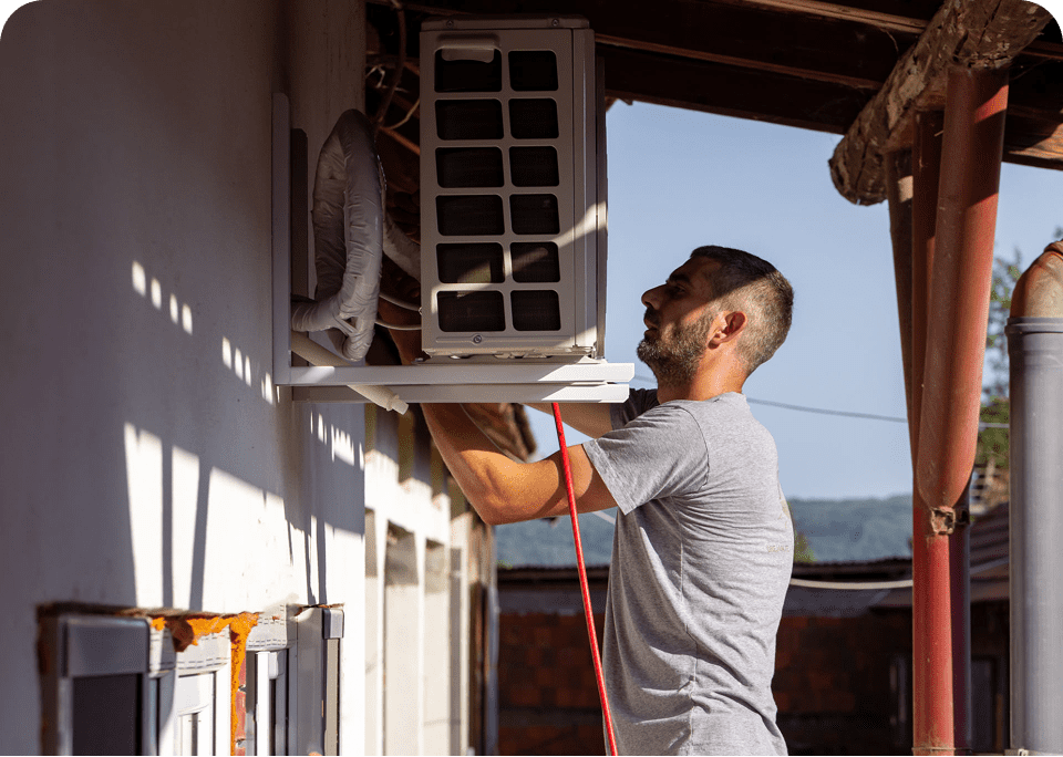 Man installing outdoor air conditioning unit.