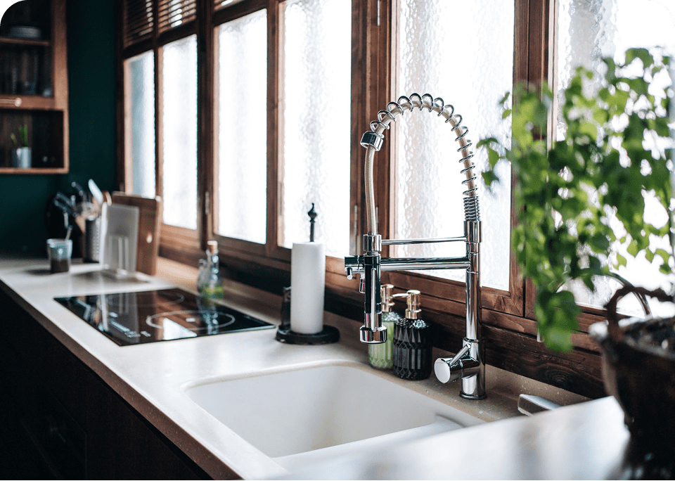 Modern kitchen sink with large window view.