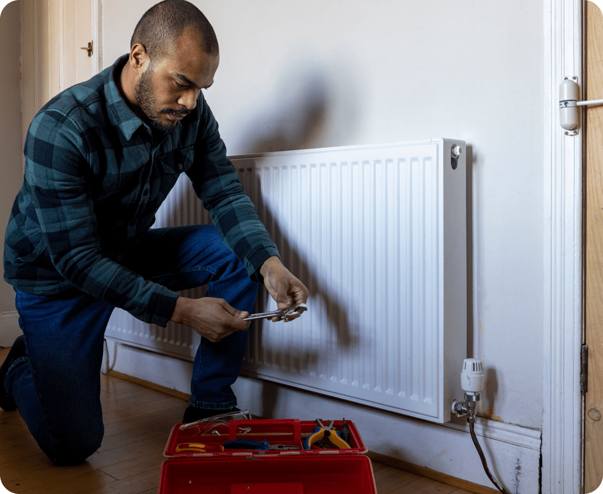 Man fixing radiator with a wrench.