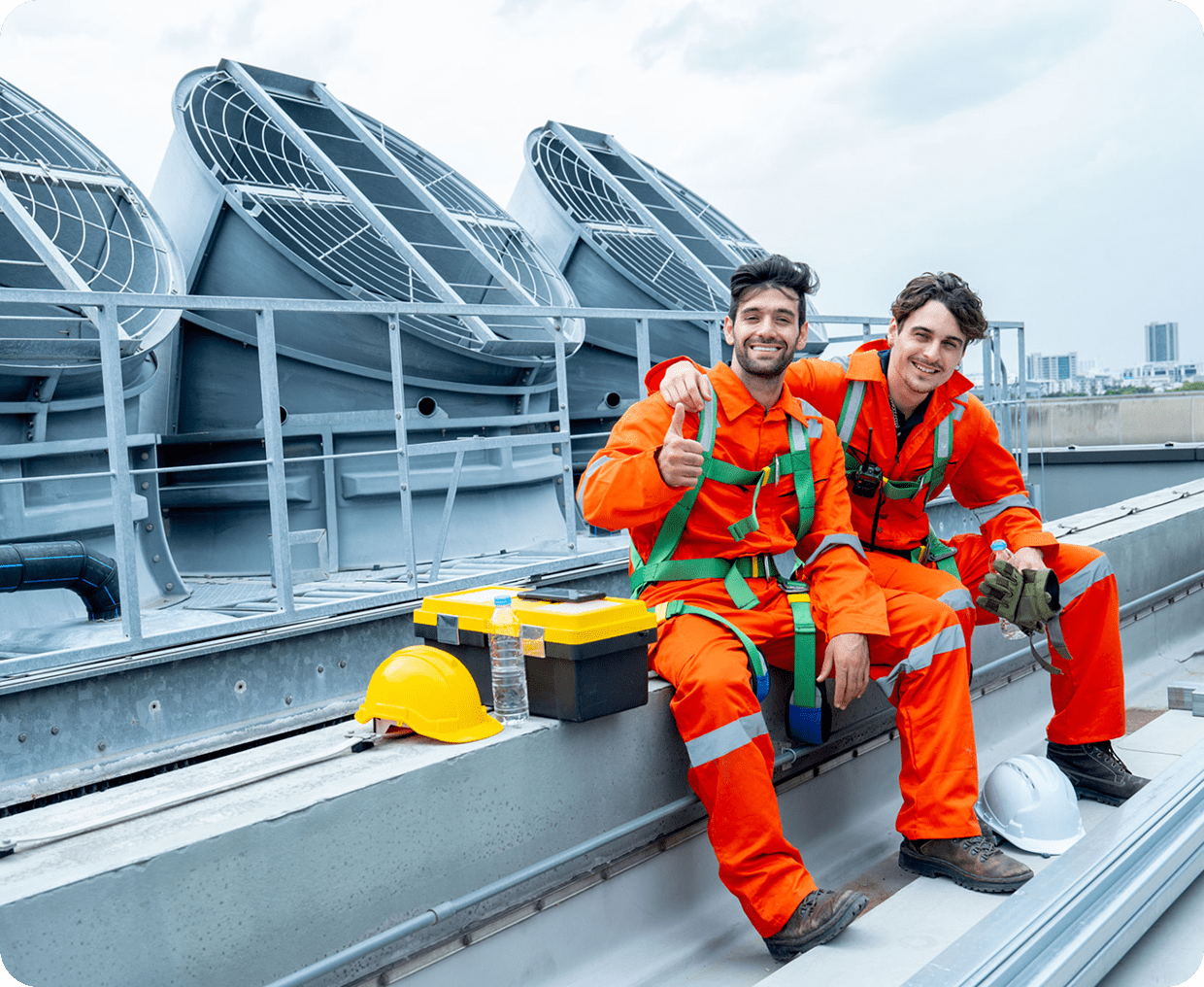 Two workers in orange uniforms on rooftop.