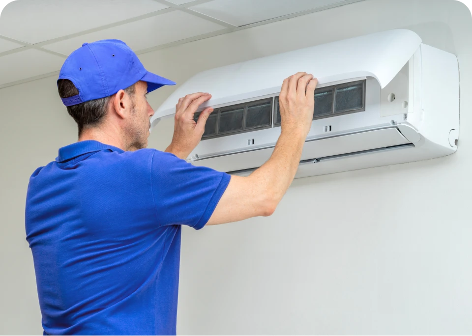 Technician inspecting wall-mounted air conditioner.