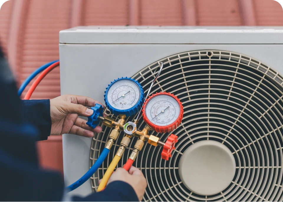 Technician checking air conditioner pressure gauges.
